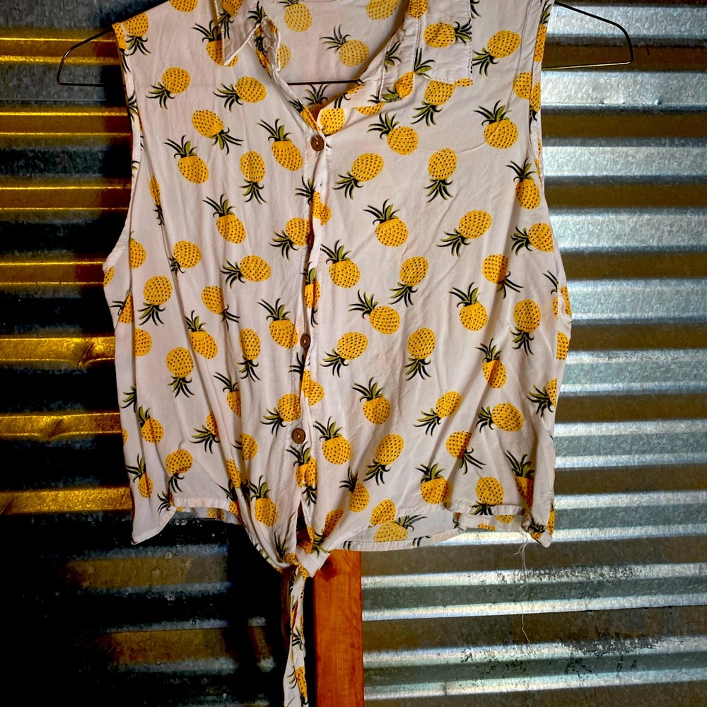 This is a mid-riff style “tie at the bottom”, sleeve-less blouse.